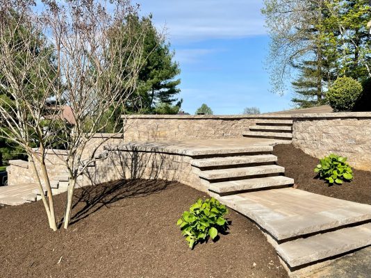 Precision-crafted stone steps and retaining walls enhance this garden's structure, adding elegance and functionality.