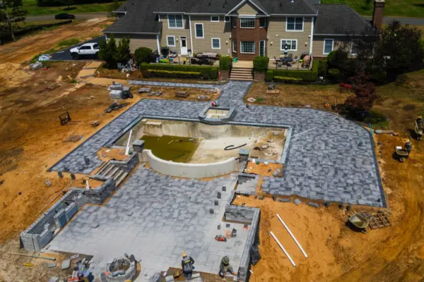 This Colts Neck, NJ backyard was transformed into a luxurious outdoor living space featuring a Nicolock patio, extensive landscaping, privacy screening, custom water and fire features, an outdoor kitchen, and elegant landscape lighting. The design blends durability and elegance, with a high-quality paver patio, soothing water features, and a fully equipped outdoor kitchen for seamless entertaining. Thoughtfully placed landscape lighting and privacy screening create a secluded and inviting atmosphere, making this space perfect for both relaxation and hosting.