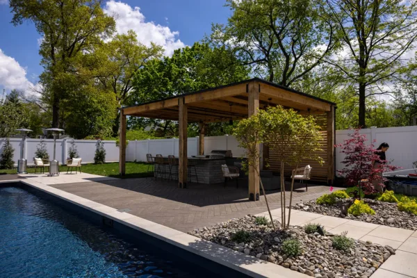 This Edison, NJ backyard was completely transformed into a stunning outdoor retreat featuring a custom pool patio, pavilion, landscape lighting, and underground water management system. The design includes durable pavers, a stylish shaded pavilion, LED lighting for ambiance and safety, and a well-planned drainage system to ensure longevity and functionality. The result is a beautiful and functional space perfect for relaxation and entertaining.